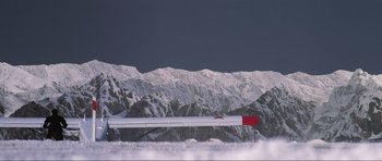 Movie still from “GoldenEye” (1995), directed by Martin Campbell – An airplane is flying over a snowy mountain range; Extreme Wide shot, High angle