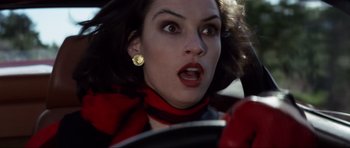 Movie still from “GoldenEye” (1995), directed by Martin Campbell – A person in a car wearing a red scarf; Close Up shot, Low angle