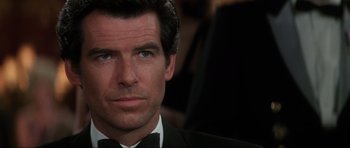 Movie still from “GoldenEye” (1995), directed by Martin Campbell – A person wearing a tuxedo; Close Up shot, Over the shoulder angle