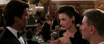 Movie still from “GoldenEye” (1995), directed by Martin Campbell – A woman in a black dress holding a wooden stick; Close Up shot, Over the shoulder angle