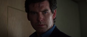 Movie still from “GoldenEye” (1995), directed by Martin Campbell – A person wearing a suit and tie; Close Up shot, Over the shoulder angle