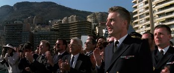 Movie still from “GoldenEye” (1995), directed by Martin Campbell – A group of men in suits and ties clapping; Medium shot, Low angle