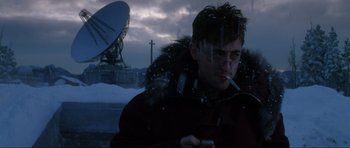 Movie still from “GoldenEye” (1995), directed by Martin Campbell – A man smoking a cigarette in front of a satellite dish; Close Up shot, Low angle