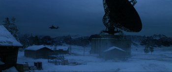 Movie still from “GoldenEye” (1995), directed by Martin Campbell – A helicopter flying over a snowy field next to an antenna; Extreme Wide shot, Low angle