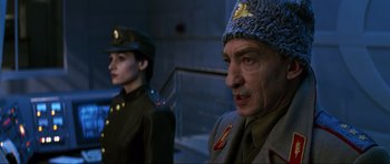 Movie still from “GoldenEye” (1995), directed by Martin Campbell – A man and a woman in military uniforms and hats; Close Up shot, Low angle