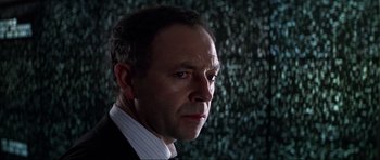 Movie still from “GoldenEye” (1995), directed by Martin Campbell – A person wearing a suit and tie; Close Up shot, Low angle