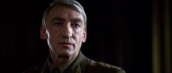 Movie still from “GoldenEye” (1995), directed by Martin Campbell – A person wearing a military uniform; Close Up shot, Low angle