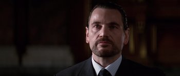 Movie still from “GoldenEye” (1995), directed by Martin Campbell – A person wearing a suit and tie; Close Up shot, Low angle
