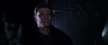 Movie still from “GoldenEye” (1995), directed by Martin Campbell – A person wearing a suit and tie; Close Up shot, Low angle