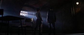 Movie still from “GoldenEye” (1995), directed by Martin Campbell – A man and a woman standing in a dark room; Wide shot, Low angle