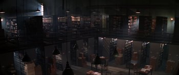 Movie still from “GoldenEye” (1995), directed by Martin Campbell – A room filled with lots of shelves and lamps in it; Extreme Wide shot, High angle