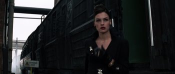 Movie still from “GoldenEye” (1995), directed by Martin Campbell – A woman in a black dress and black leather gloves; Close Up shot, Low angle