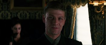 Movie still from “GoldenEye” (1995), directed by Martin Campbell – A person wearing a suit and tie; Close Up shot, Low angle