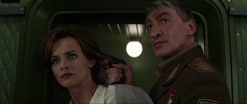 Movie still from “GoldenEye” (1995), directed by Martin Campbell – A woman holding a gun next to a man with a gun; Close Up shot, Low angle