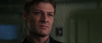 Movie still from “GoldenEye” (1995), directed by Martin Campbell – A person wearing a suit and tie; Close Up shot, Low angle