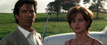 Movie still from “GoldenEye” (1995), directed by Martin Campbell – A man and a woman standing next to each other in a field; Close Up shot, Low angle
