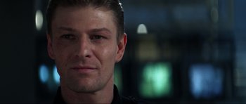 Movie still from “GoldenEye” (1995), directed by Martin Campbell – A person wearing a black shirt; Close Up shot, Over the shoulder angle