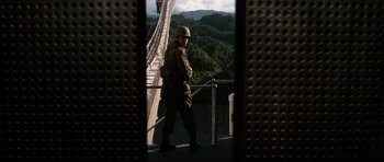 Movie still from “GoldenEye” (1995), directed by Martin Campbell – A man in uniform walking across a bridge; Wide shot, Low angle