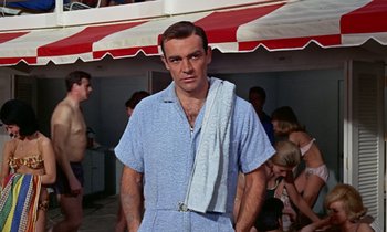 Movie still from “Goldfinger” (1964), directed by Guy Hamilton – A man with a towel around his neck; Medium shot, Low angle