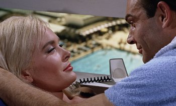 Movie still from “Goldfinger” (1964), directed by Guy Hamilton – A man and a woman in front of a swimming pool; Close Up shot, Overhead angle