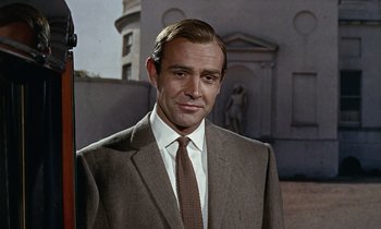 Movie still from “Goldfinger” (1964), directed by Guy Hamilton – A person wearing a suit and tie; Close Up shot, Low angle