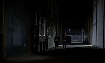 Movie still from “Goldfinger” (1964), directed by Guy Hamilton – Two people walking down a dark street at night; Extreme Wide shot, High angle