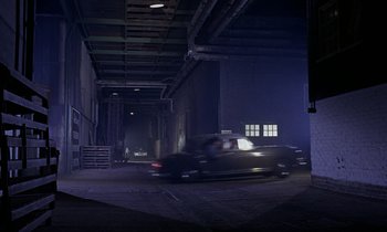 Movie still from “Goldfinger” (1964), directed by Guy Hamilton – A car driving down a dark street at night; Extreme Wide shot, High angle