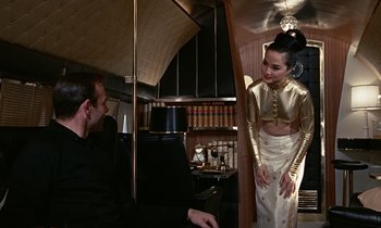 Movie still from “Goldfinger” (1964), directed by Guy Hamilton – A man and a woman are standing next to each other; Medium shot, Low angle