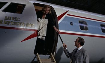 Movie still from “Goldfinger” (1964), directed by Guy Hamilton – A man and a woman getting out of an airplane; Medium shot, Overhead angle