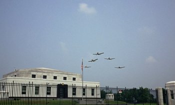 Movie still from “Goldfinger” (1964), directed by Guy Hamilton – A group of planes flying in formation over a building; Extreme Wide shot, Low angle