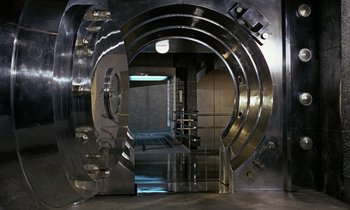 Movie still from “Goldfinger” (1964), directed by Guy Hamilton – An open door to a room with a large metal door; Wide shot, High angle