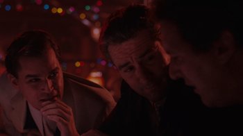 Movie still from “Goodfellas” (1990), directed by Martin Scorsese – A group of people sitting in front of lights; Medium shot, Over the shoulder angle