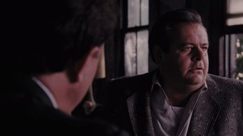 Movie still from “Goodfellas” (1990), directed by Martin Scorsese – Two men are sitting in a dark room; Close Up shot, Over the shoulder angle