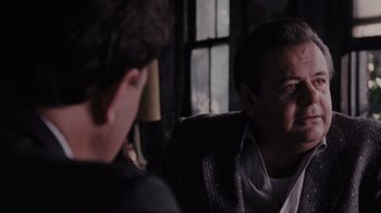 Movie still from “Goodfellas” (1990), directed by Martin Scorsese – Two men are sitting in a chair and one of them is wearing headphones; Close Up shot, Over the shoulder angle