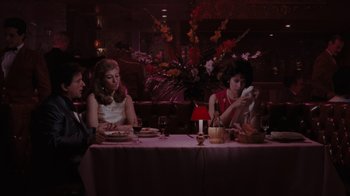 Movie still from “Goodfellas” (1990), directed by Martin Scorsese – A group of people sitting at a table in a restaurant; Medium shot, Over the shoulder angle