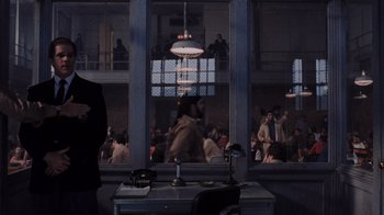 Movie still from “Goodfellas” (1990), directed by Martin Scorsese – A group of people standing in a room with windows; Wide shot, Over the shoulder angle
