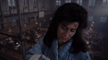 Movie still from “Goodfellas” (1990), directed by Martin Scorsese – A woman in a blue jacket is looking down at the floor; Close Up shot, High angle