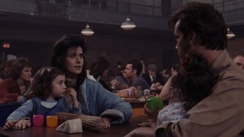 Movie still from “Goodfellas” (1990), directed by Martin Scorsese – A group of people sitting at a table with drinks; Medium shot, Over the shoulder angle