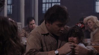 Movie still from “Goodfellas” (1990), directed by Martin Scorsese – A man holding a pen in his hand while sitting at a table with other people; Close Up shot, Over the shoulder angle