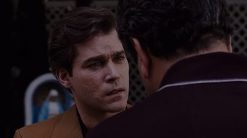 Movie still from “Goodfellas” (1990), directed by Martin Scorsese – A man is looking at another man with a serious look on his face; Close Up shot, Over the shoulder angle