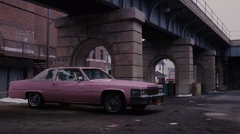 Movie still from “Goodfellas” (1990), directed by Martin Scorsese – A pink car parked in front of an overpass; Wide shot, High angle