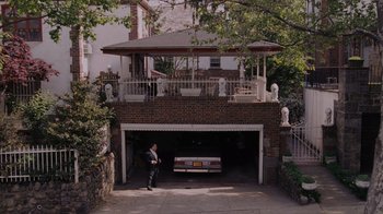 Movie still from “Goodfellas” (1990), directed by Martin Scorsese – A man standing in front of a car parked in a garage; Extreme Wide shot, High angle