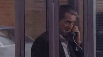 Movie still from “Goodfellas” (1990), directed by Martin Scorsese – A man talking on a phone while sitting at a desk; Close Up shot, Low angle