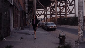 Movie still from “Goodfellas” (1990), directed by Martin Scorsese – A woman walking down a street near a fire hydrant; Wide shot, High angle