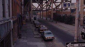 Movie still from “Goodfellas” (1990), directed by Martin Scorsese – A group of cars parked on the side of the street; Extreme Wide shot, High angle