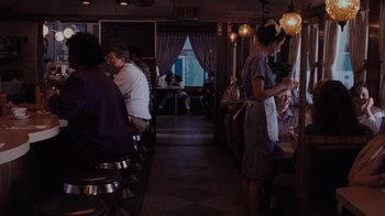 Movie still from “Goodfellas” (1990), directed by Martin Scorsese – A group of people sitting at a table in a restaurant; Wide shot, Over the shoulder angle