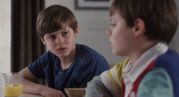 Movie still from “Goodnight Mommy” (2022), directed by Matt Sobel – Two young boys sitting at a dining room table; Close Up shot, Over the shoulder angle