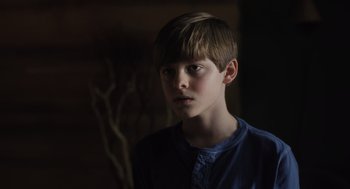 Movie still from “Goodnight Mommy” (2022), directed by Matt Sobel – A young boy is looking into the camera; Close Up shot, Low angle