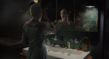 Movie still from “Goodnight Mommy” (2022), directed by Matt Sobel – A woman is standing in front of a bathroom mirror; Medium shot, Over the shoulder angle