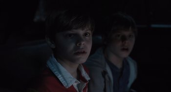 Movie still from “Goodnight Mommy” (2022), directed by Matt Sobel – Two young boys sitting in front of a television; Close Up shot, Over the shoulder angle